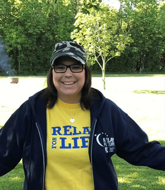 Dianne standing outside wearing a Relay for Life shirt and hoodie.