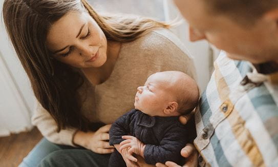 Danielle and her husband looking at her baby.