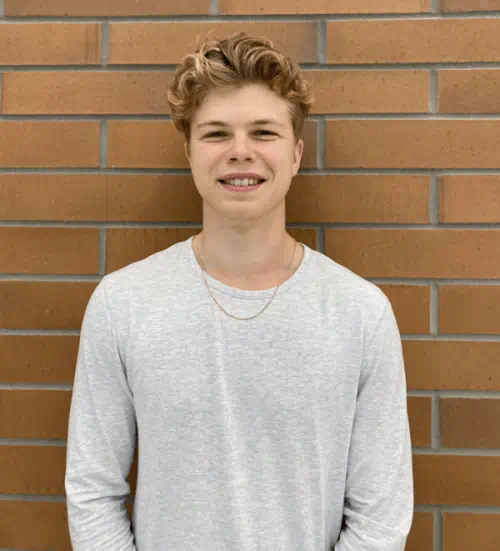 Owen, standing in front of a brick wall.