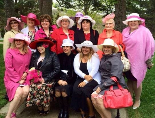 Linda and the Pink Days in Bloom volunteers, wearing pink formal attire and hats.