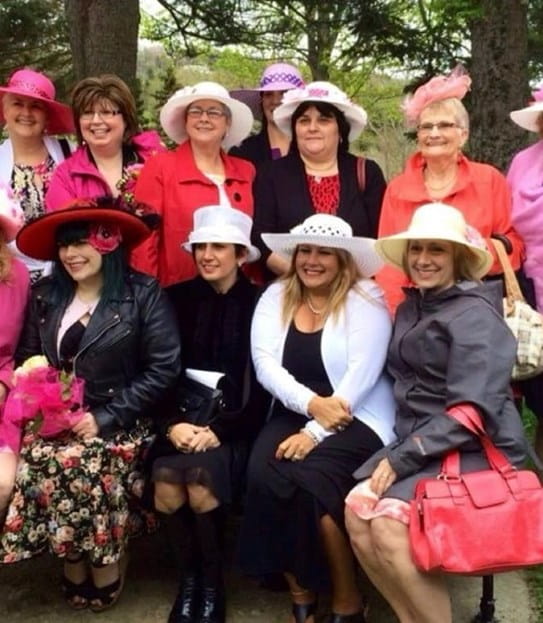 Linda and the Pink Days in Bloom volunteers, wearing pink formal attire and hats.