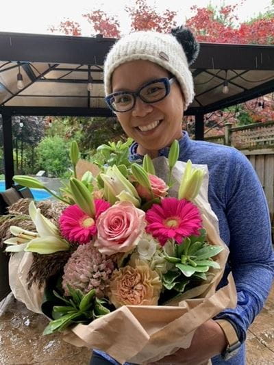 Margarita holding a bouquet of flowers on Run Day.