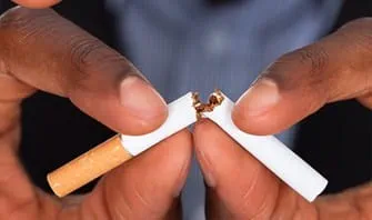 A hand breaking cigarette in half.
