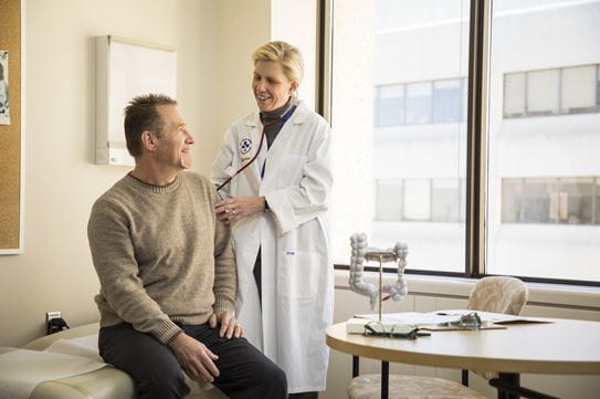 Dr Rebecca Auer examining a man in her clinic