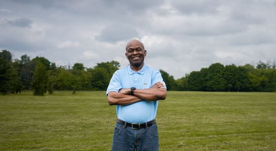 Anthony Henry standing in a field smiling at the camera.