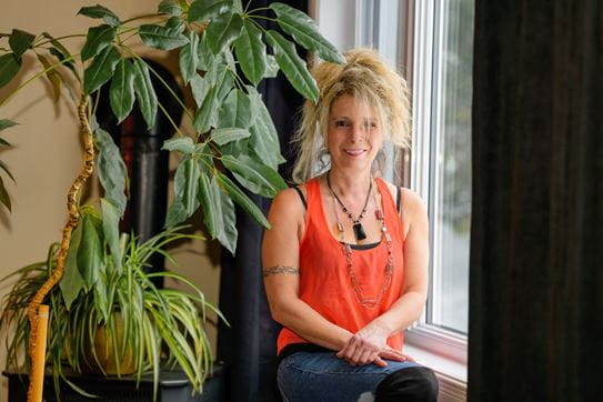 Nathalie Breton sitting on a windowsill.