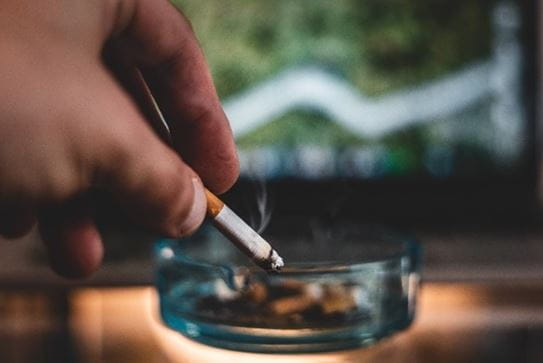 Putting out cigarette in an ashtray.