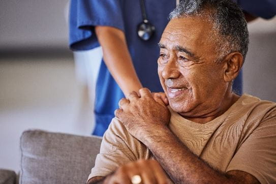 A caregiver holding hand of a sad person and showing kindness.