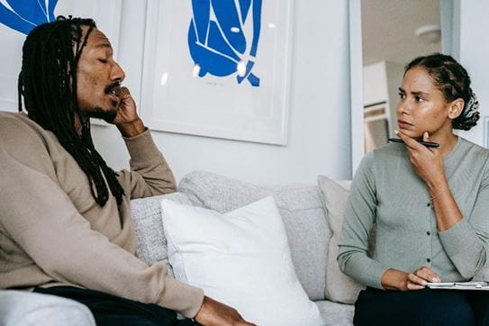 A person talking to a counsellor on a couch.