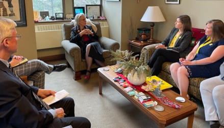 Un groupe de personnes discutant, assises autour d’une table