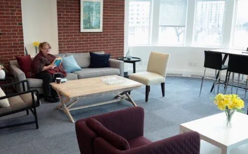 A woman reading a book while sitting on a couch
