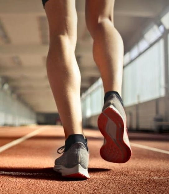 A person's legs running on a track