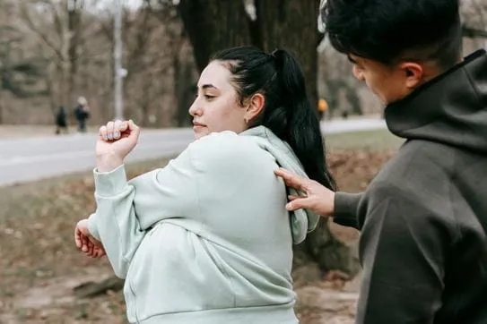 A woman stretching her arms and a man touching her back