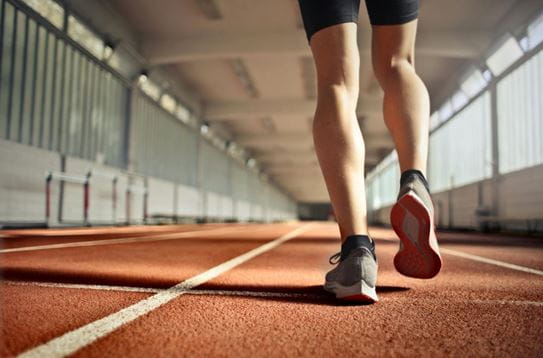 A person’s legs running on a track
