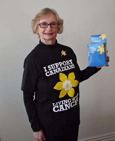 Karen White, wearing a Daffodil Month t-shirt and holding a donation box.