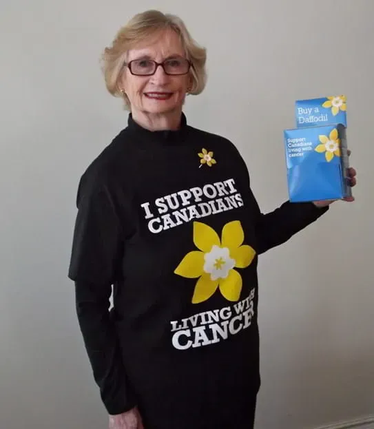 Karen White, wearing a Daffodil Month t-shirt and holding a donation box.