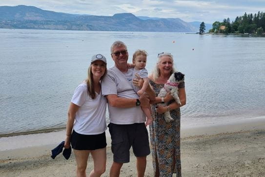 Doug Berry standing with his family on a beach