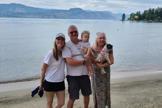 Doug Berry debout sur une plage, entouré de sa famille