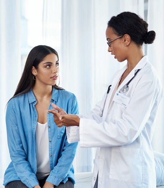 A patient sitting down and talking to her doctor