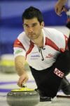 Craig SAvill holding a curling rock, preparing to make a shot at the Tim Hortons Brier.