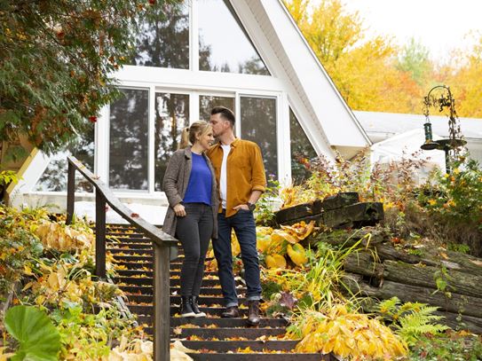 Emily stands in front of her chalet with her partner