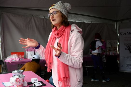 Marie-Noëlle parlant à quelqu'un, debout devant une table