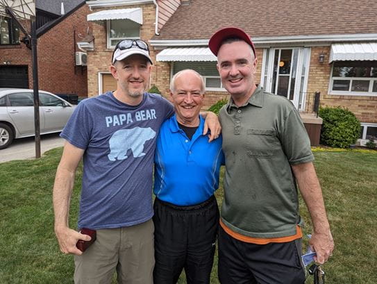 Jerry Howarth standing between his two sons.