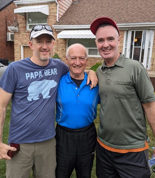 Jerry Howarth standing between his two sons.