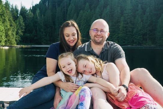 The Hatfield family smiling and laughing on a dock at Camp Goodtimes.