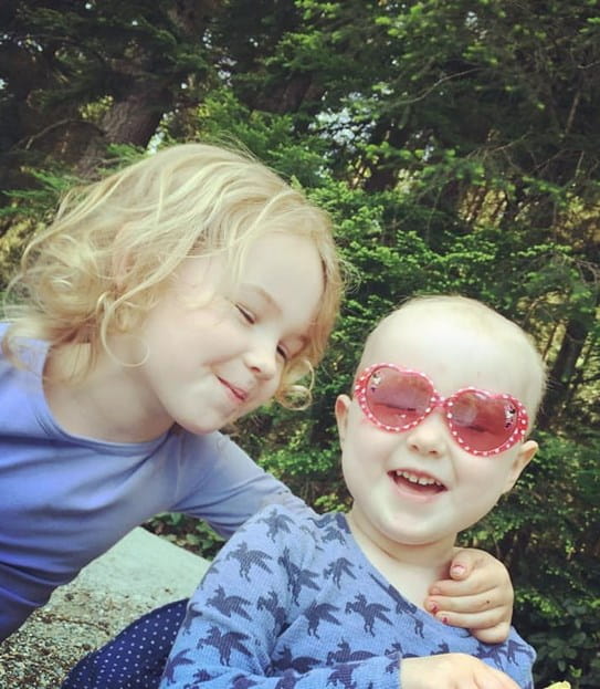 Elu and Inara, smiling and laughing in a nature park.