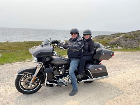 Louise-Hélène is riding a motorcycle with her partner.
