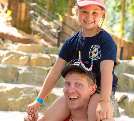 Paisley sitting on her father’s shoulders while they smile at the camera