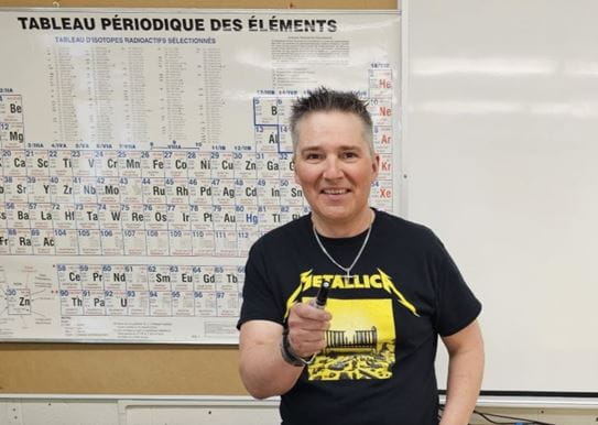 Sébastien in front of a whiteboard in his science classroom