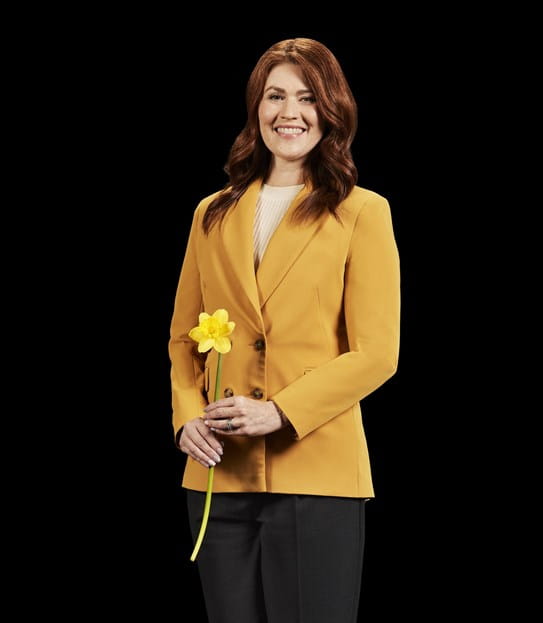 Cassidy London smiling and holding a daffodil