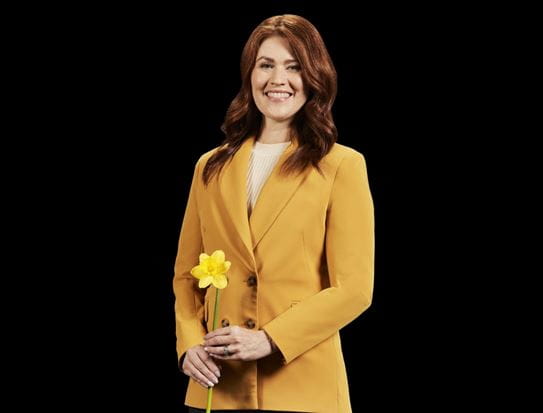 Cassidy London smiling and holding a daffodil.