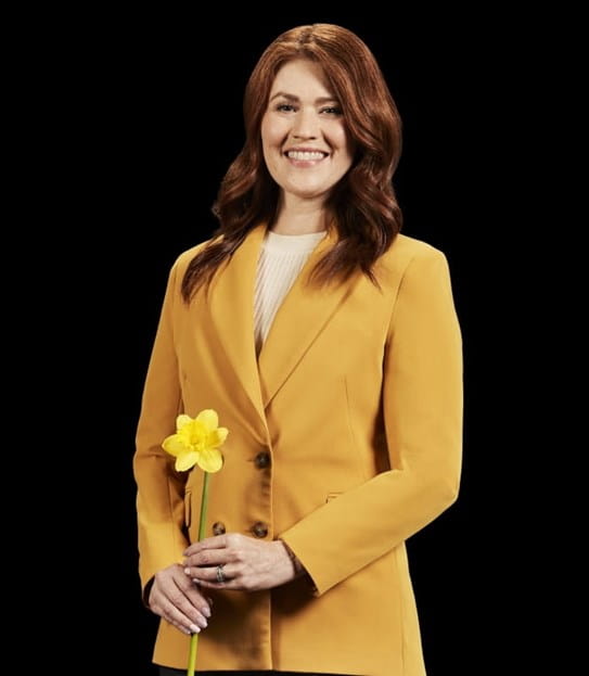 Cassidy London smiling and holding a daffodil.