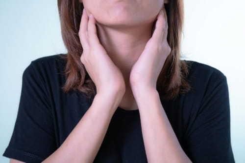 A person touching the sides of their neck.