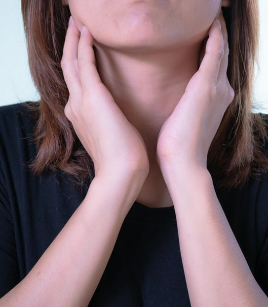 A person touching the sides of their neck.