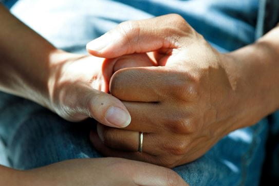 Deux mains qui se tiennent. L’une d’entre elles porte une bague.