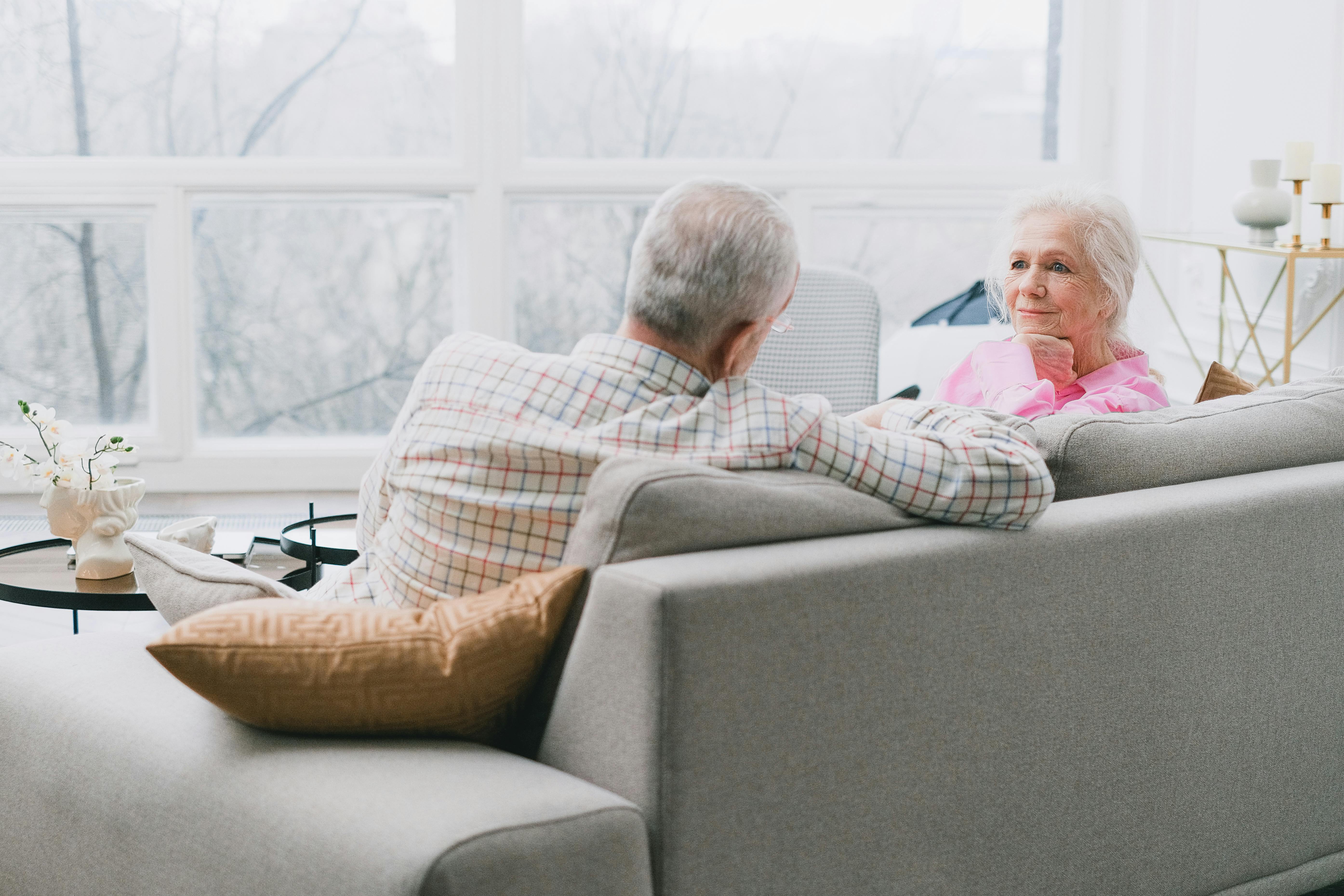 A couple sitting on the couch facing each other.