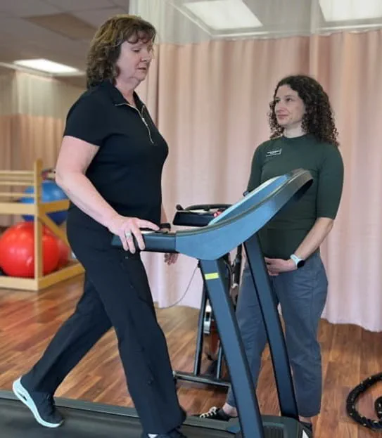 Terri Swain-Collins marche sur un tapis roulant pendant que sa physiothérapeute l’observe.