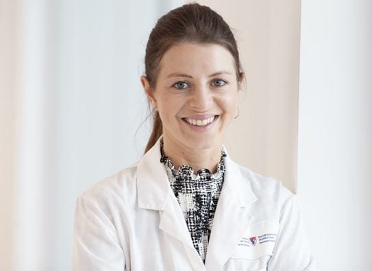 A headshot of researcher Dr Julia Burnier, who is wearing a McGill University lab coat.