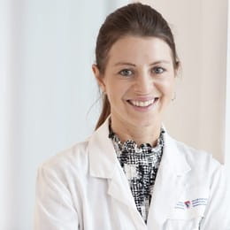 A headshot of researcher Dr Julia Burnier, who is wearing a McGill University lab coat.