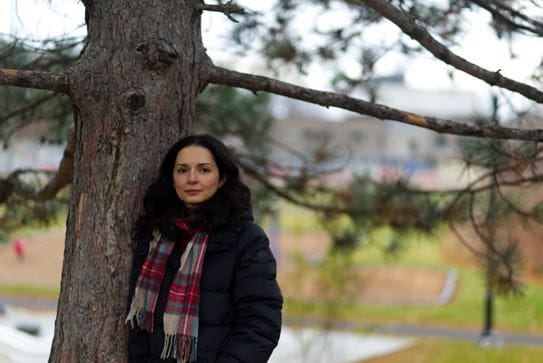 Salimeh leaning against a tree.