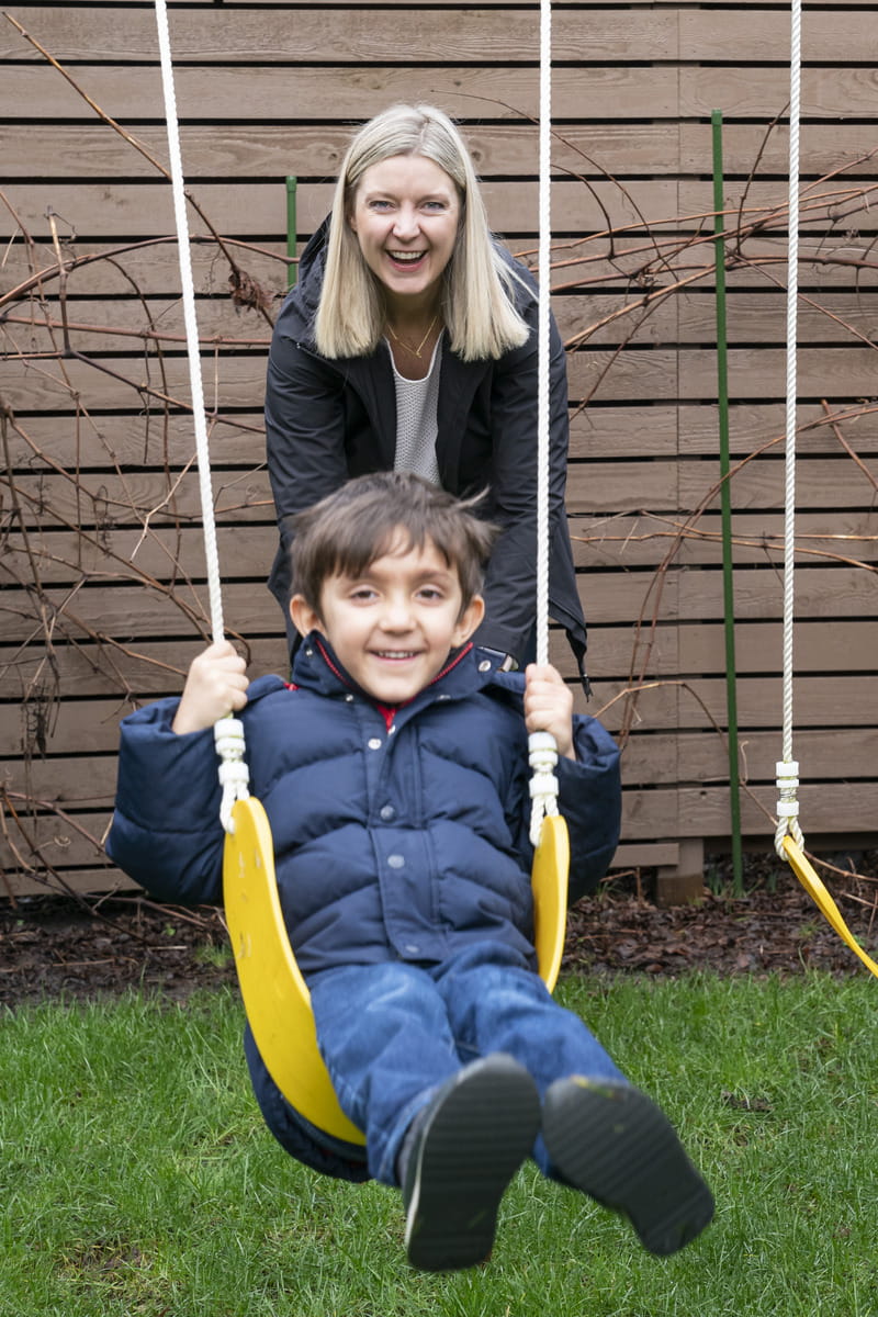Kathy, pushing her son on a swing.