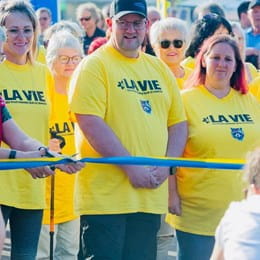 Jimmy Morel est debout derrière la ligne de départ, entourés de participants d’espoir en t-shirt jaune.