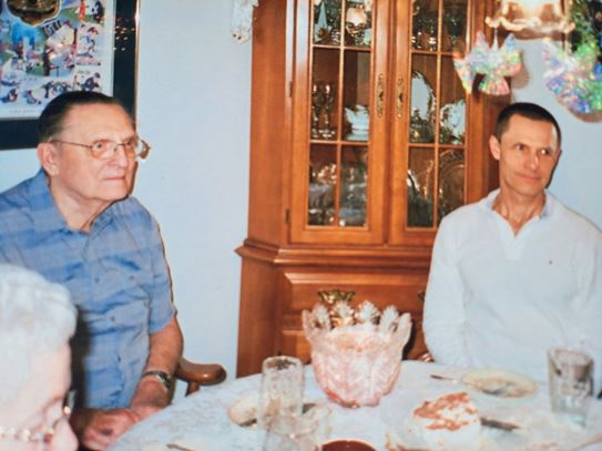(left to right): Ron Luciuk’s father and Ron sitting at a dining room table together.