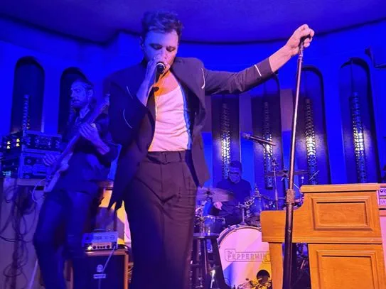 Shawn Hook singing into a microphone on stage.