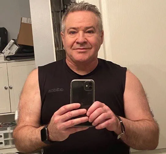 Steven Hodges holding his phone to take a photo of himself in the mirror.