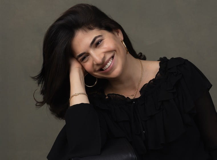 Robby Spring with her hand in her hair and smiling.